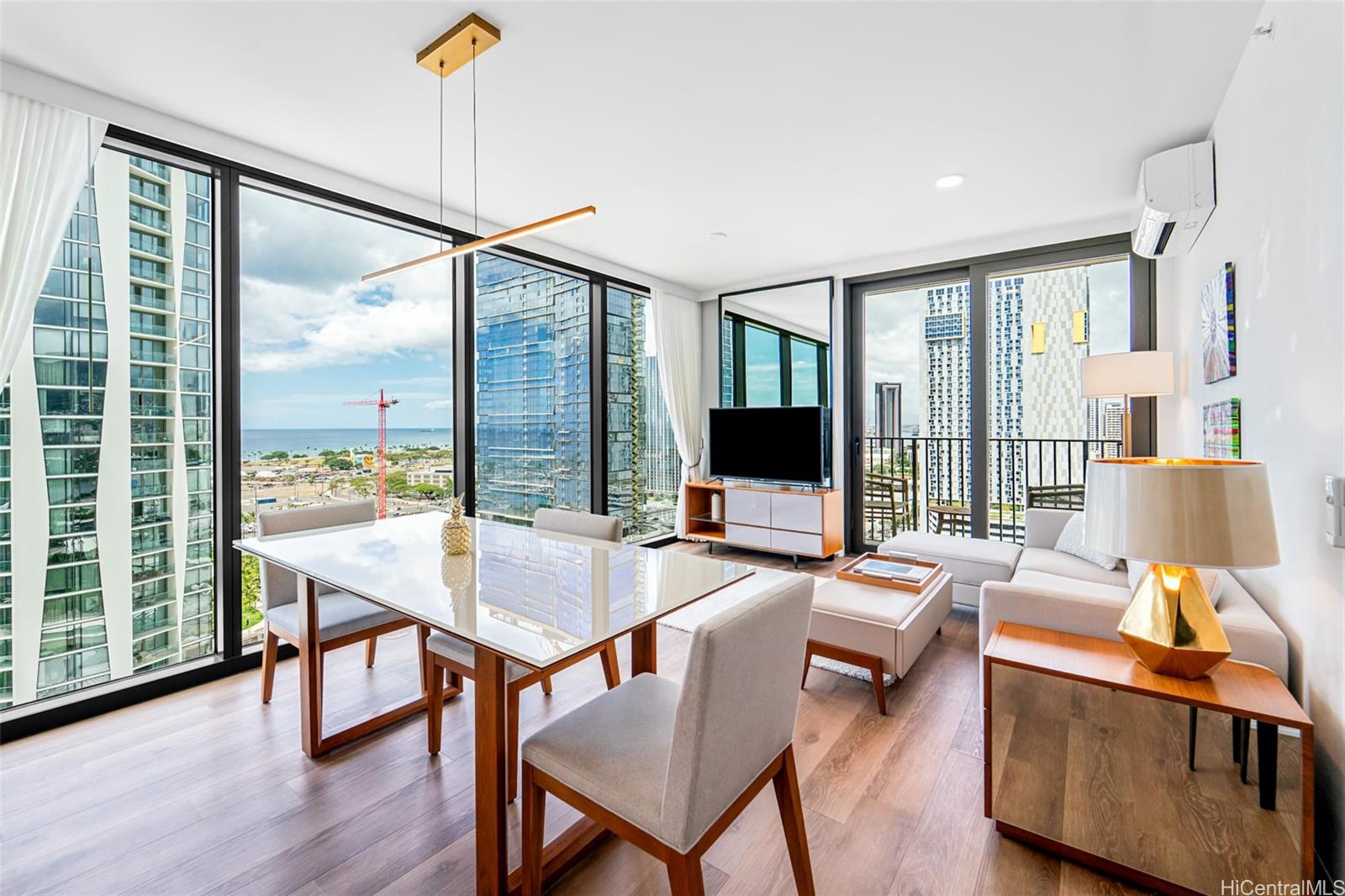 987 Queen Street, Unit 2001 Honolulu, HI 96814 - Photo 5 of 6 a living room with furniture a flat screen tv and a large window