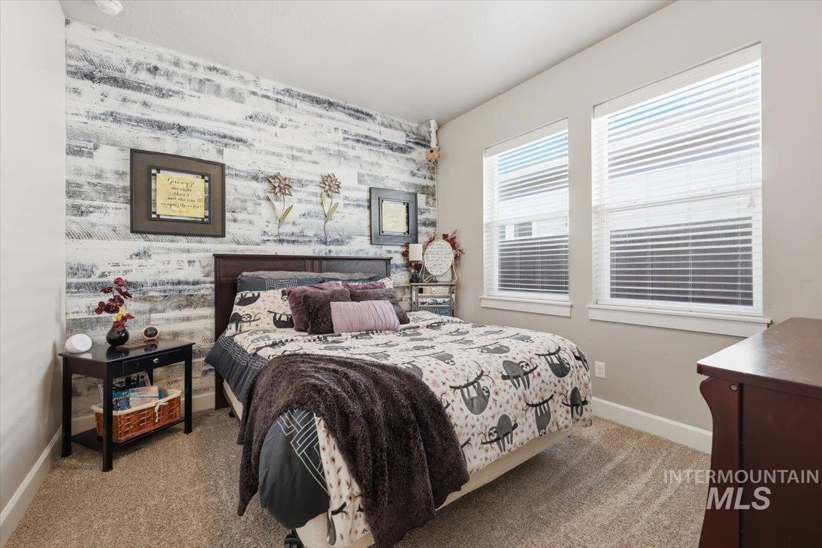 1303 West Brando Street Meridian, ID 83646 - Photo 6 of 49 Bedroom featuring a wood-panel accent wall and two large windows