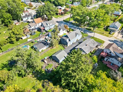 an aerial view of residential houses with outdoor space and trees