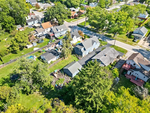 an aerial view of residential houses with outdoor space and trees