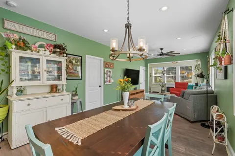 a view of a dining room with furniture a kitchen and chandelier