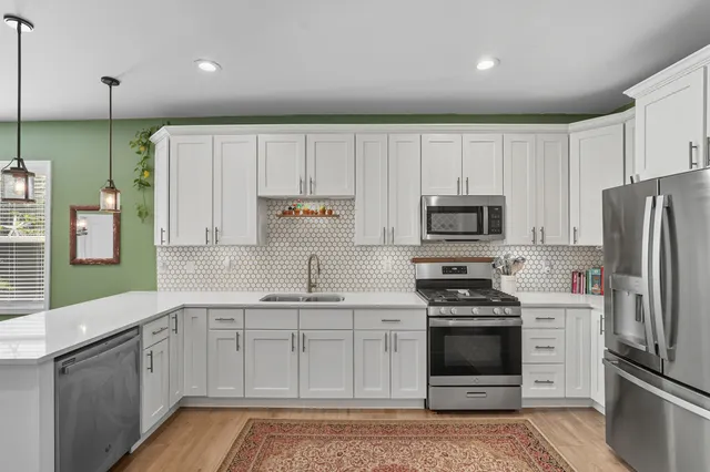 a kitchen with kitchen island white cabinets stainless steel appliances and sink
