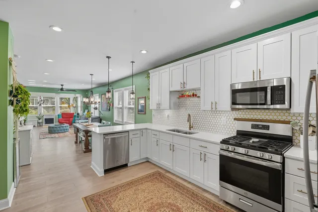 a kitchen with a sink stainless steel appliances and white cabinets