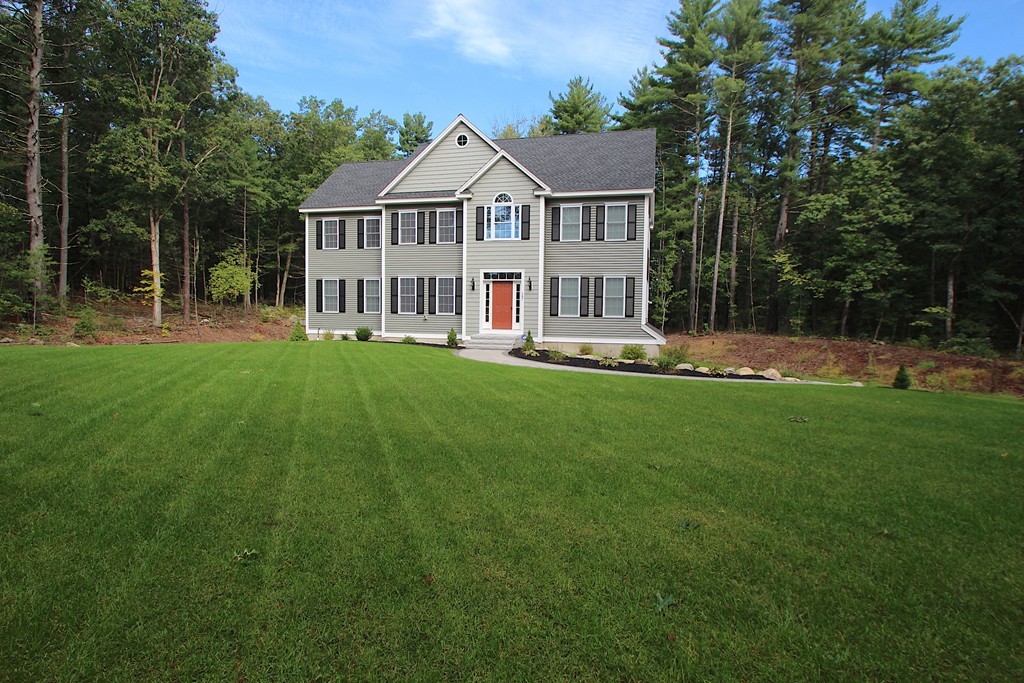a view of a house with a big yard and large trees