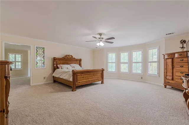 a spacious bedroom with a bed and a chair