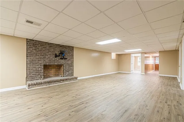 an empty room with wooden floor and fireplace