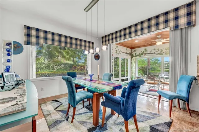 a dining room with furniture a large window and a chandelier