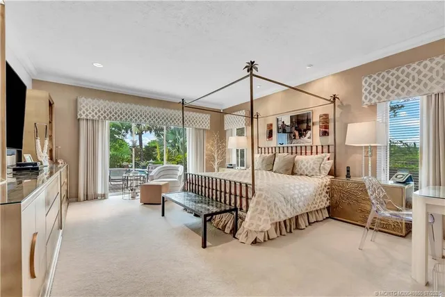 a bedroom with a large bed and a flat tv screen