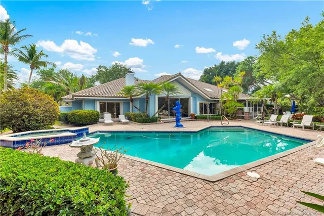 a view of a house with swimming pool and sitting area