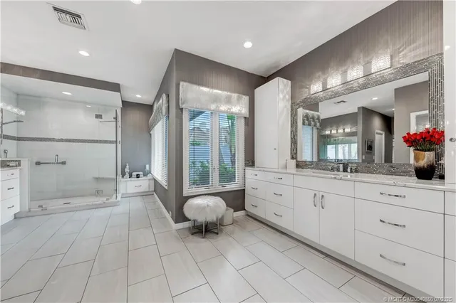 a spacious bathroom with a mirror and shower