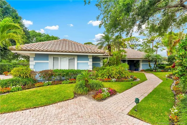 a front view of a house with a yard and potted plants