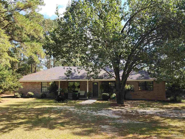 a front view of a house with a yard garage and tree