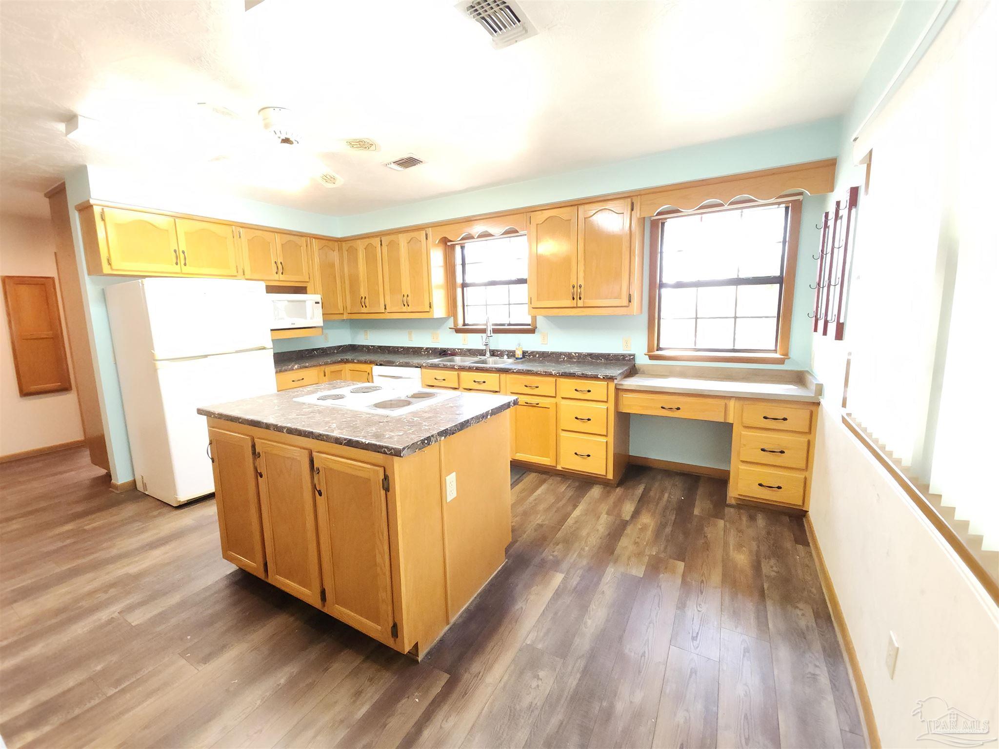 5560 Morgan Road Walnut Hill, FL 32568 - Photo 15 of 63 a kitchen with stainless steel appliances granite countertop a stove a sink and a refrigerator