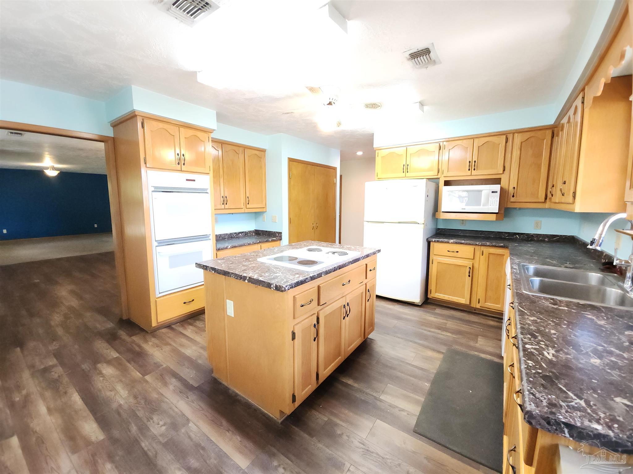 5560 Morgan Road Walnut Hill, FL 32568 - Photo 16 of 63 a kitchen with stainless steel appliances granite countertop wooden cabinets and a granite counter tops