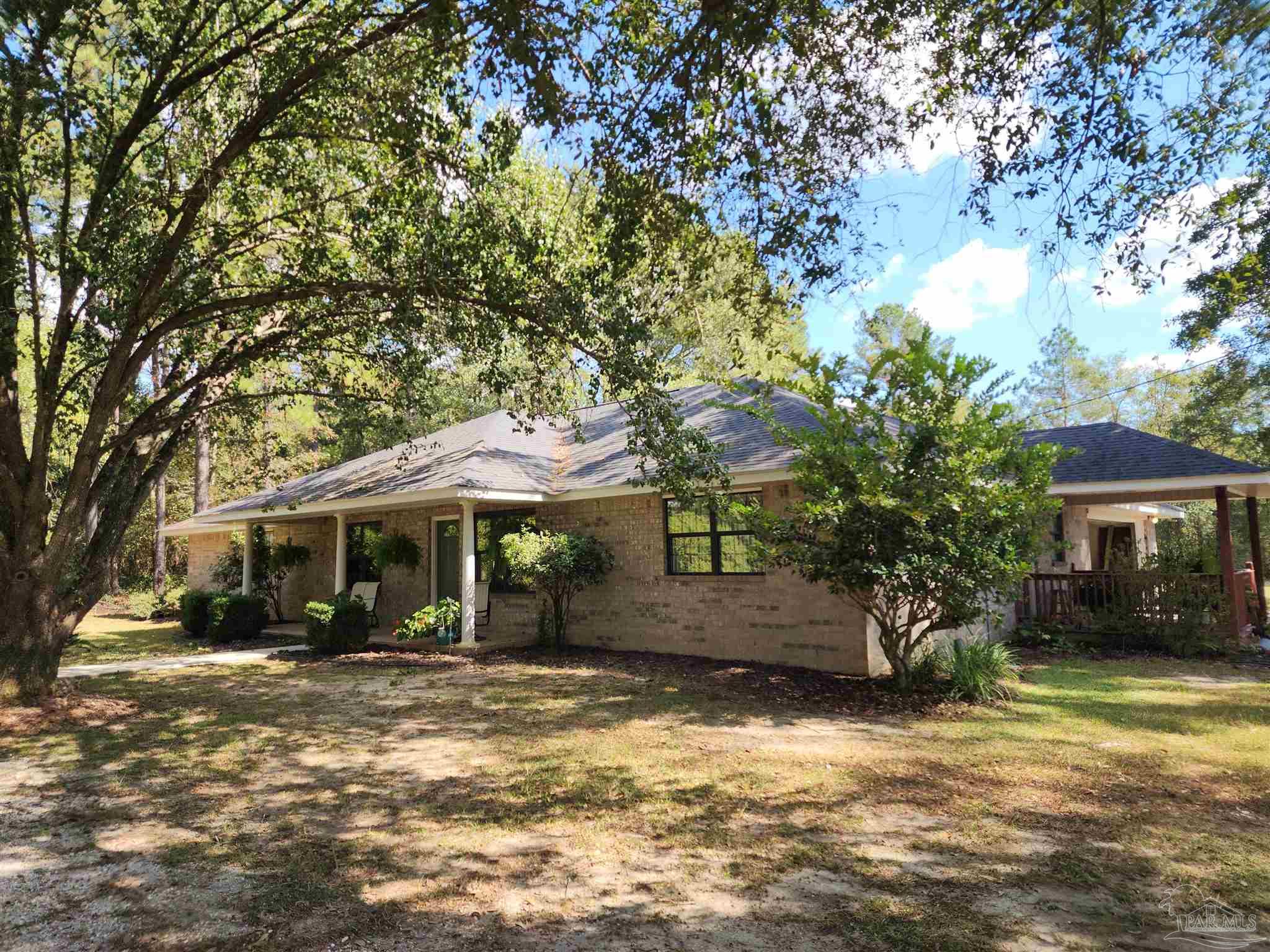 5560 Morgan Road Walnut Hill, FL 32568 - Photo 2 of 63 a front view of a house with a yard garage and tree