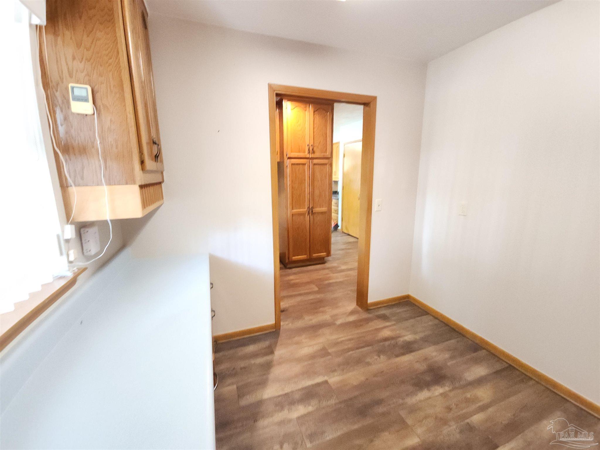 5560 Morgan Road Walnut Hill, FL 32568 - Photo 27 of 63 a view of a hallway with wooden floor and a bathroom
