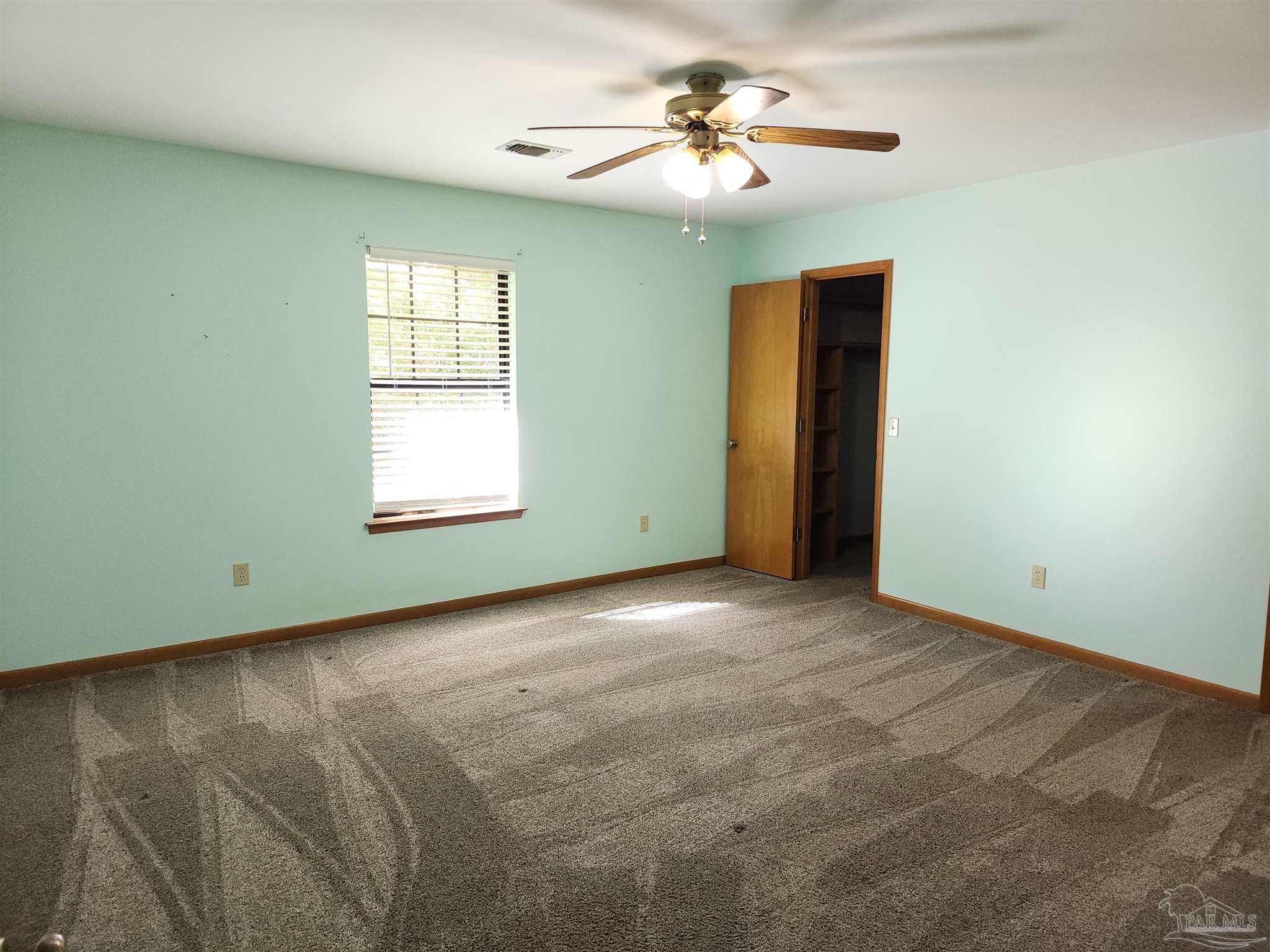 5560 Morgan Road Walnut Hill, FL 32568 - Photo 28 of 63 an empty room with windows and fan