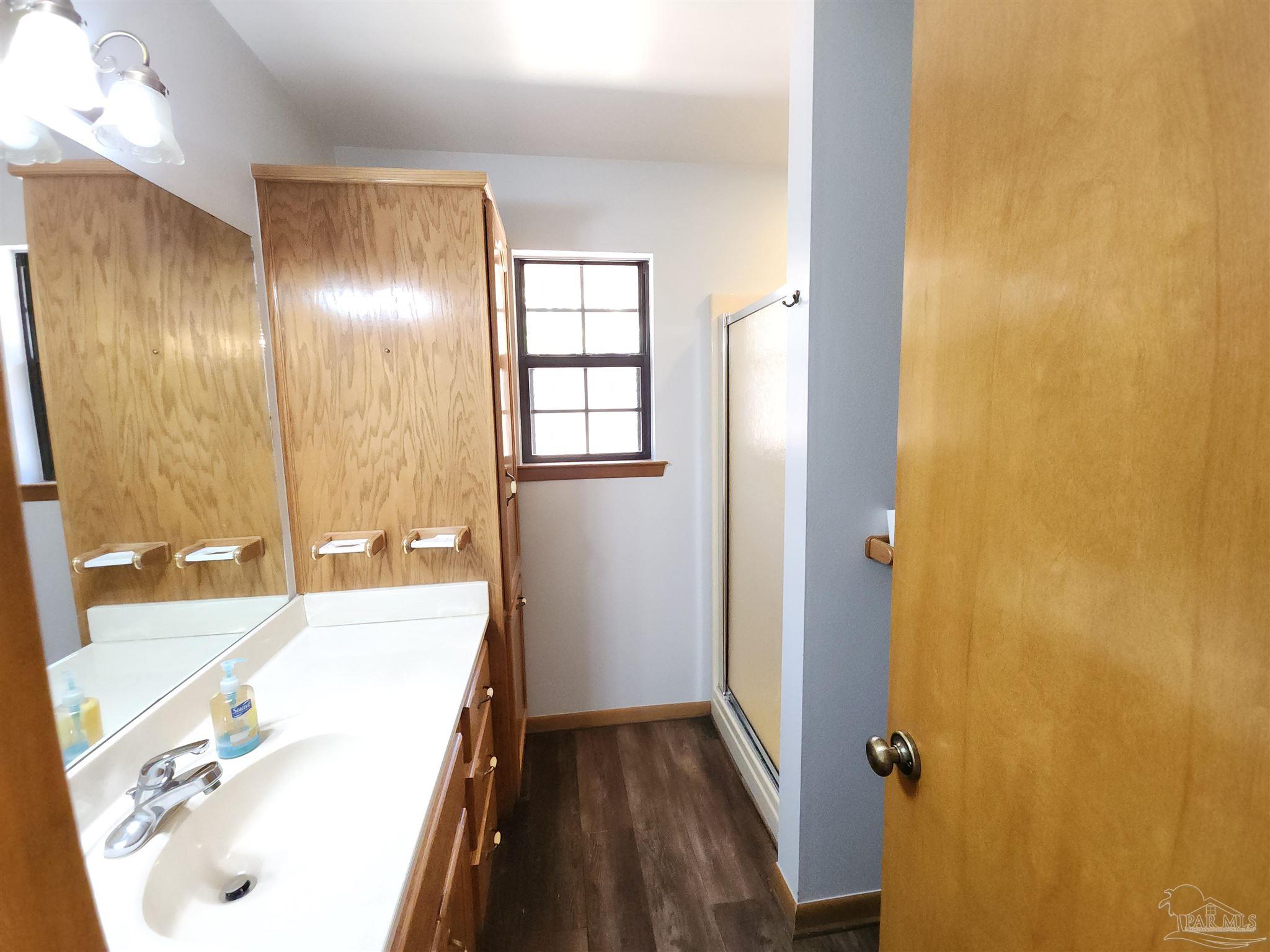5560 Morgan Road Walnut Hill, FL 32568 - Photo 31 of 63 a bathroom with a tub sink and mirror