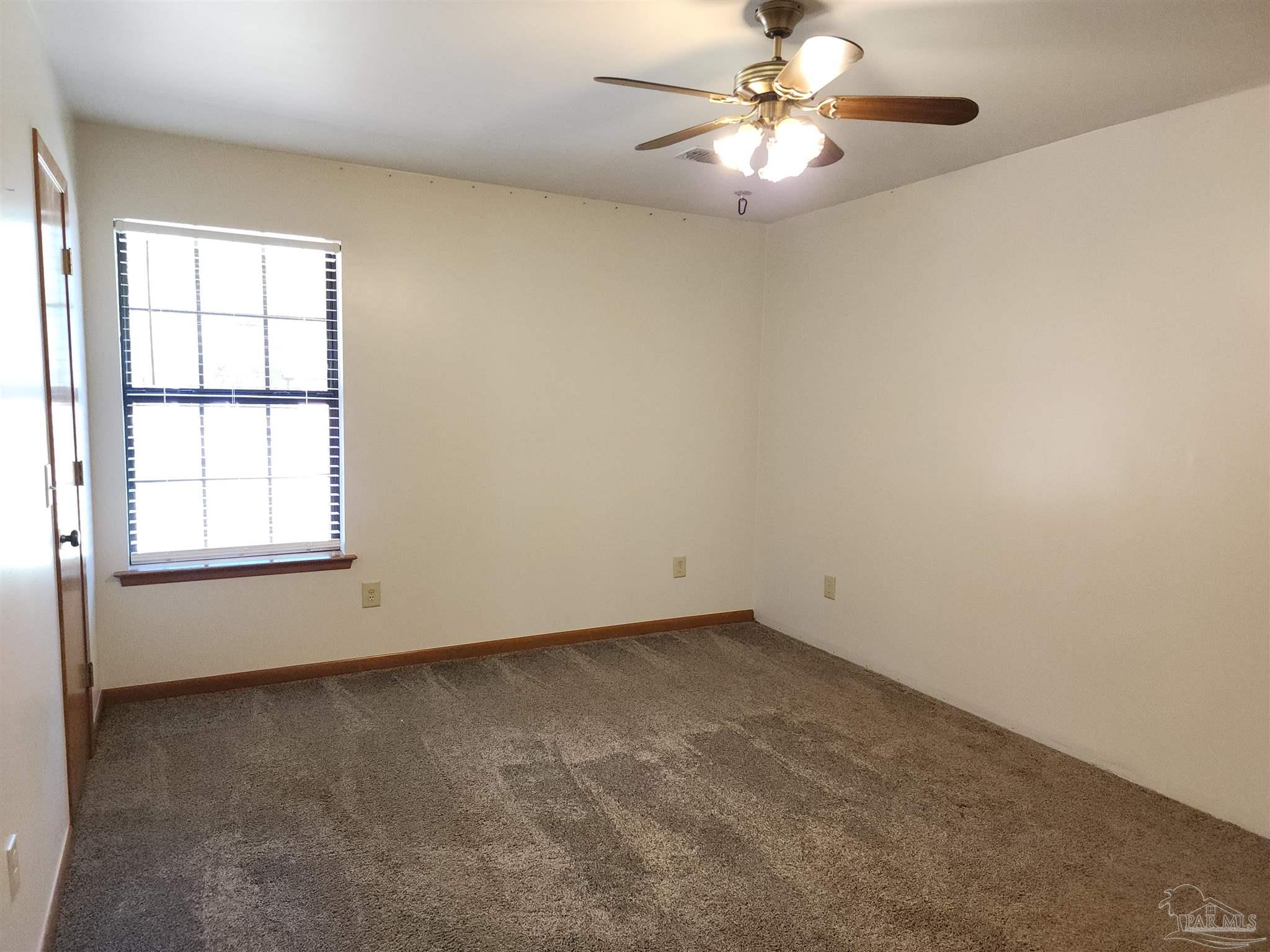 5560 Morgan Road Walnut Hill, FL 32568 - Photo 33 of 63 an empty room with windows and fan