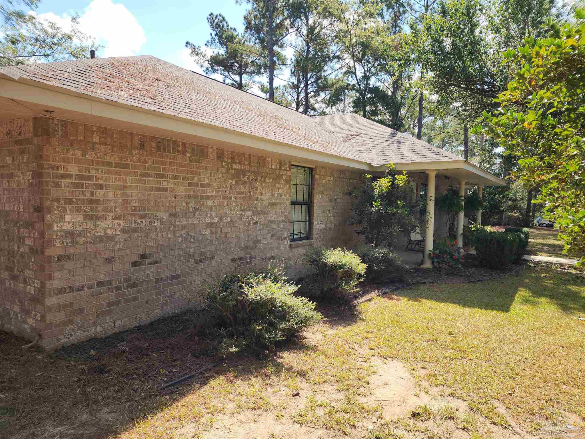 5560 Morgan Road Walnut Hill, FL 32568 - Photo 44 of 63 a view of a patio with table and chairs under an umbrella