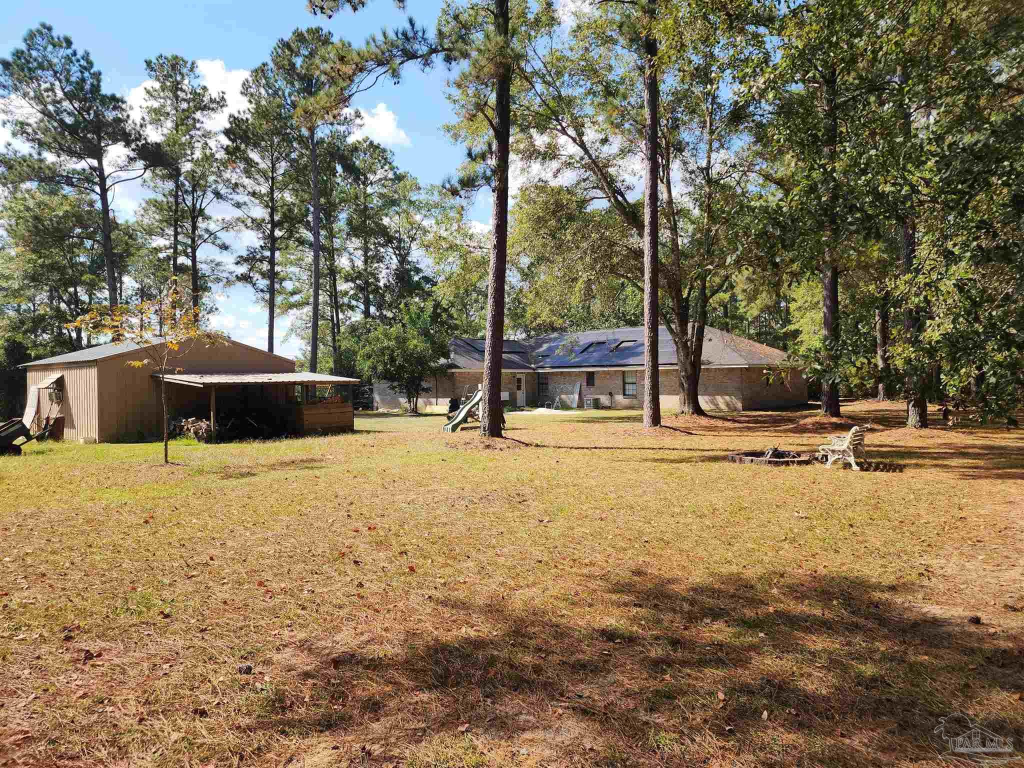 5560 Morgan Road Walnut Hill, FL 32568 - Photo 54 of 63 a view of swimming pool with lawn chairs and large trees