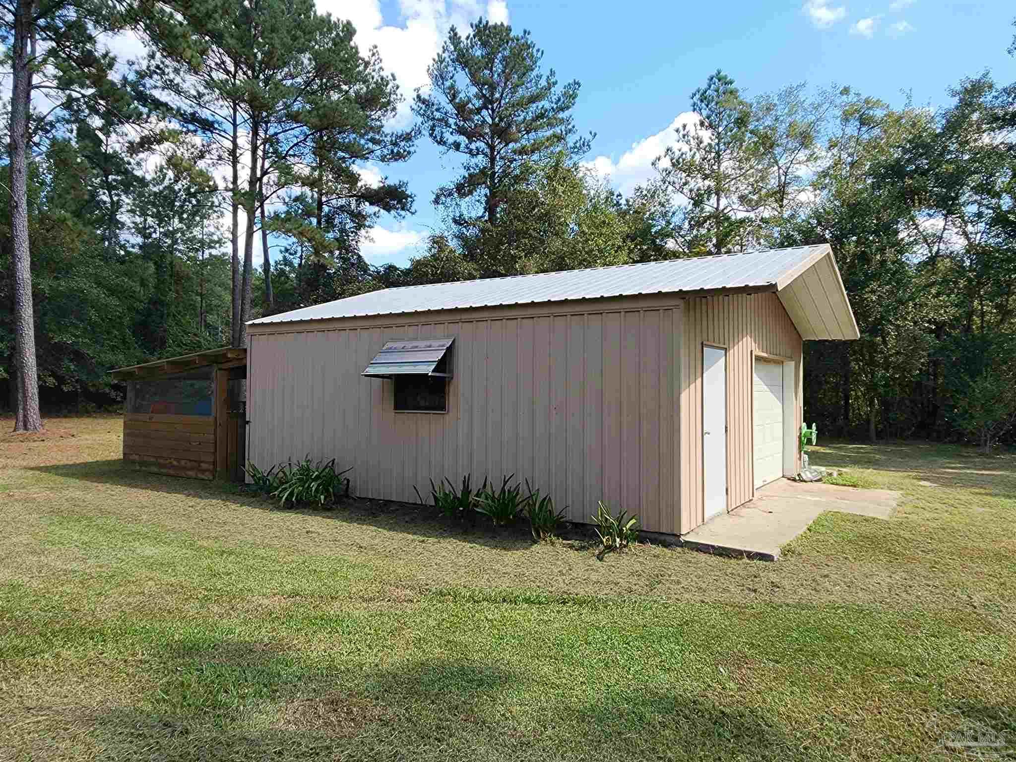 5560 Morgan Road Walnut Hill, FL 32568 - Photo 6 of 63 a backyard of a house with lots of trees and plants