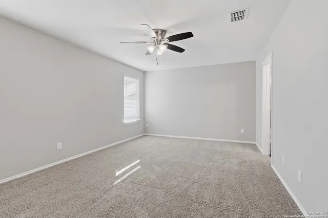 a view of an empty room with a ceiling fan