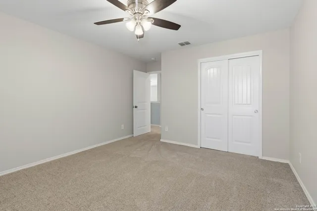 an empty room with a chandelier fan