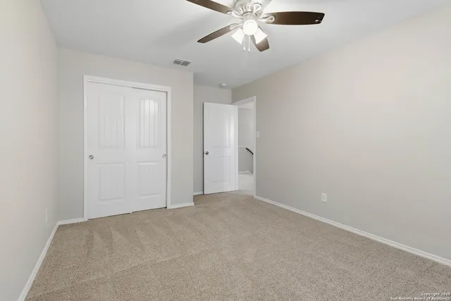 an empty room with a chandelier fan