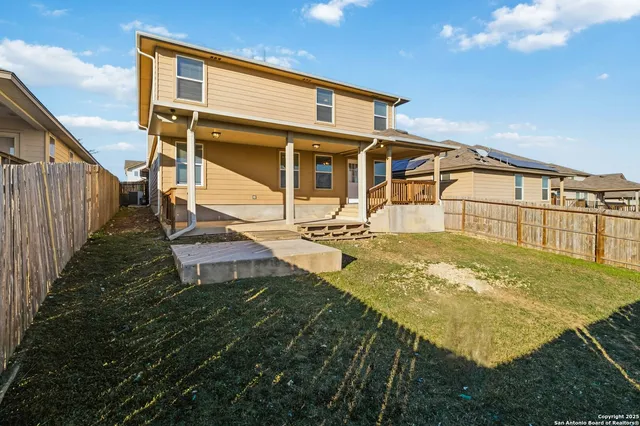 a view of a white house with large windows and a small yard