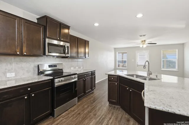a kitchen with stainless steel appliances granite countertop a sink stove and microwave