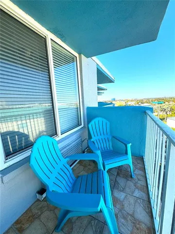 a view of a chairs and table in the balcony