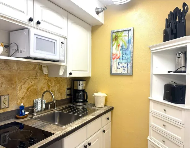 a kitchen with a sink stove and cabinets