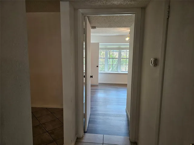 a view of a hallway with wooden floor and closet