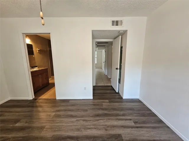 a view of a hallway with wooden floor and closet