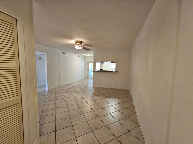 a view of a hallway to rooms and wooden floor