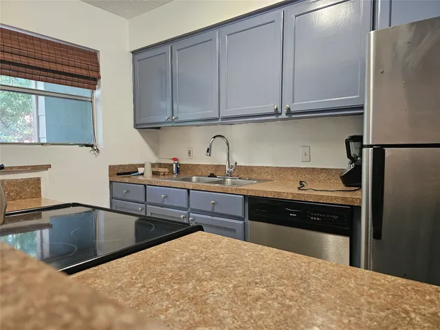 a kitchen with stainless steel appliances granite countertop a refrigerator sink and cabinets