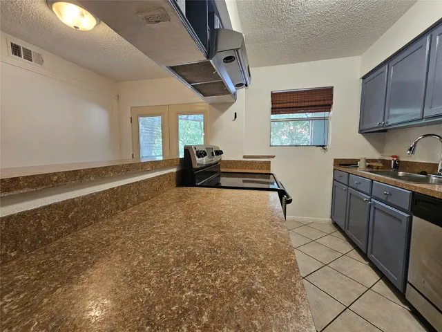 a kitchen with stainless steel appliances granite countertop a refrigerator and stove