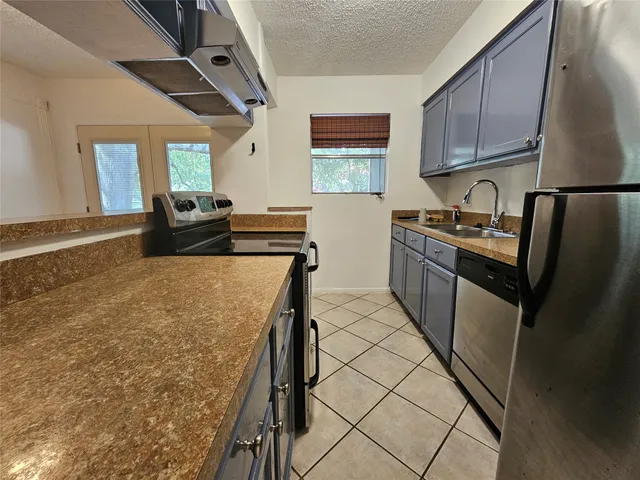 a kitchen with granite countertop a sink stove and refrigerator