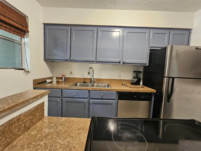 a kitchen with a sink cabinets and stainless steel appliances
