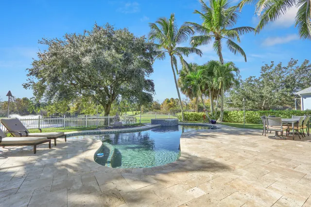 a patio with a table and chairs and a big yard