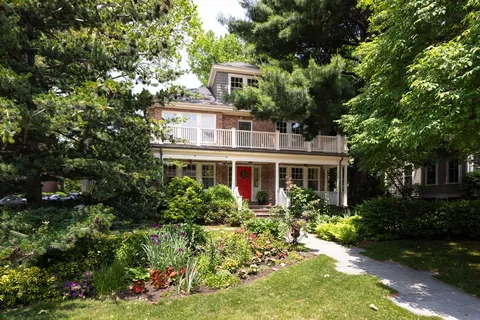a front view of a house with a yard and potted plants