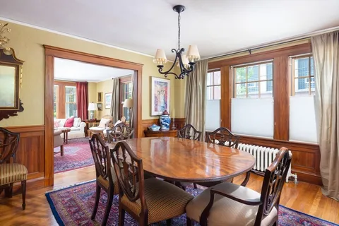 a view of a a dining room with furniture window and wooden floor