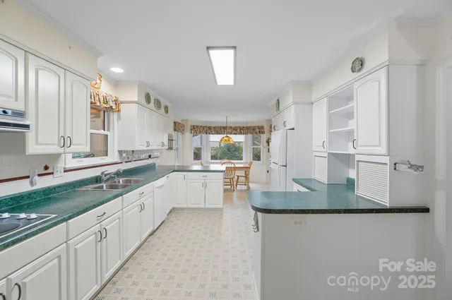 a large kitchen with granite countertop a sink a window and stainless steel appliances