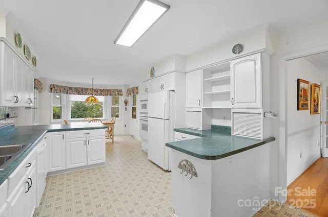a kitchen with white cabinets and white appliances