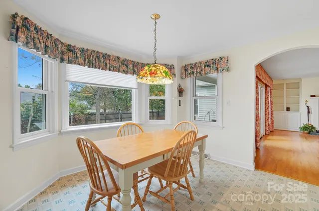 a dining room with furniture a chandelier and wooden floor