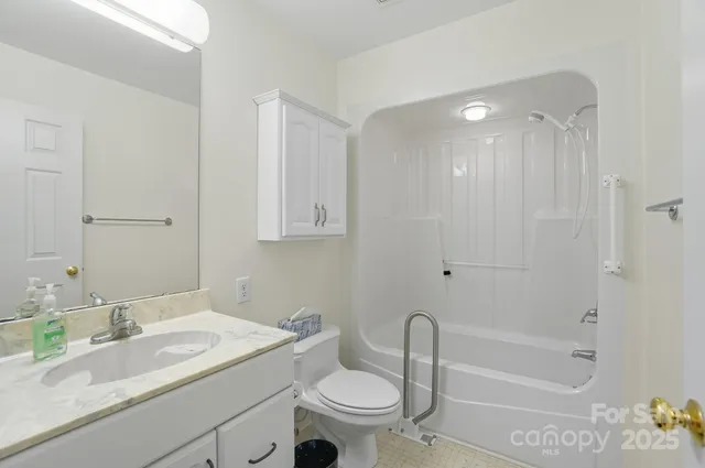 a bathroom with a granite countertop sink a toilet and shower