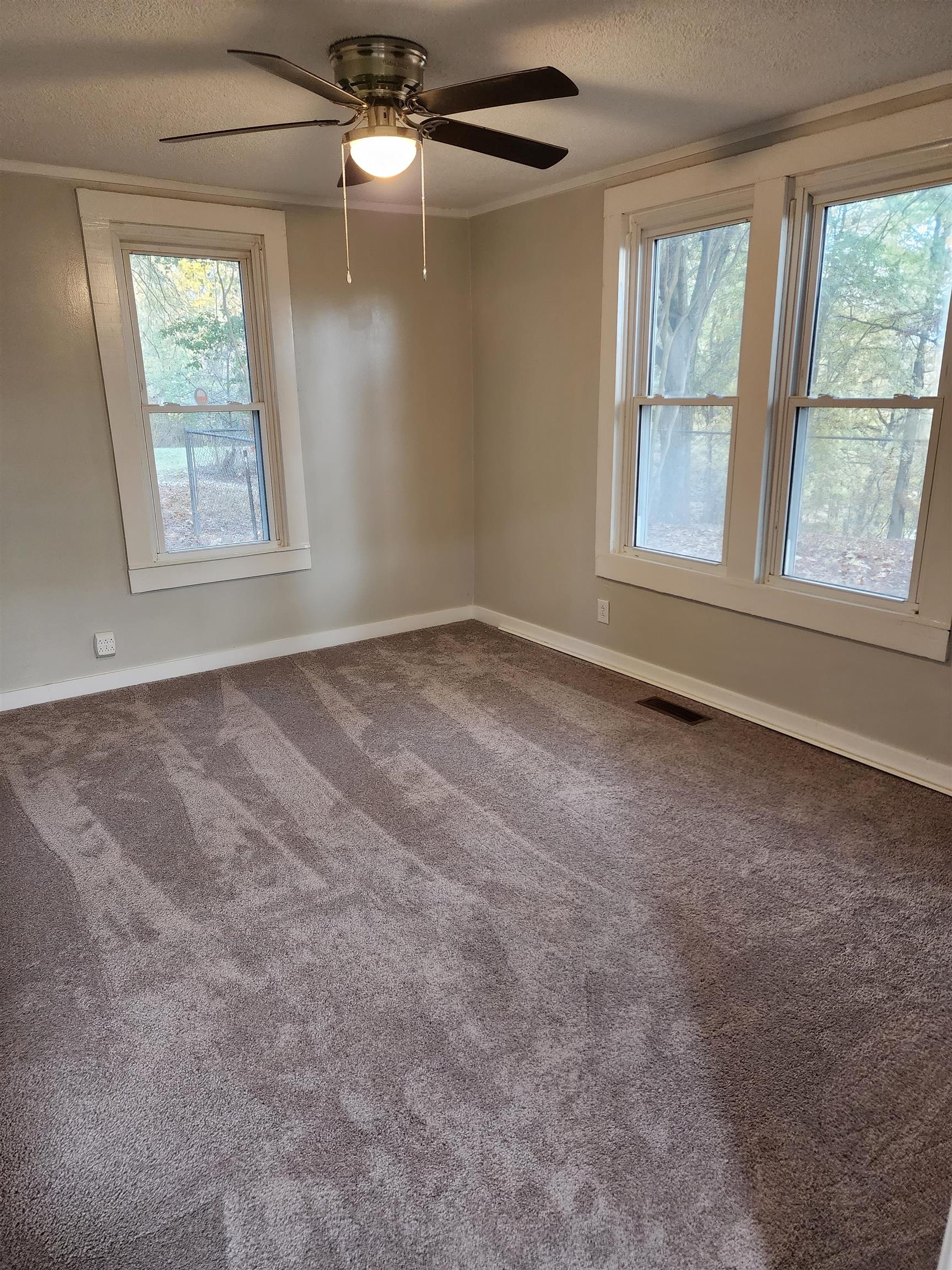 1235 Cedar Grove Road Ripley, TN 38063 - Photo 8 of 12 an empty room with windows and chandelier fan