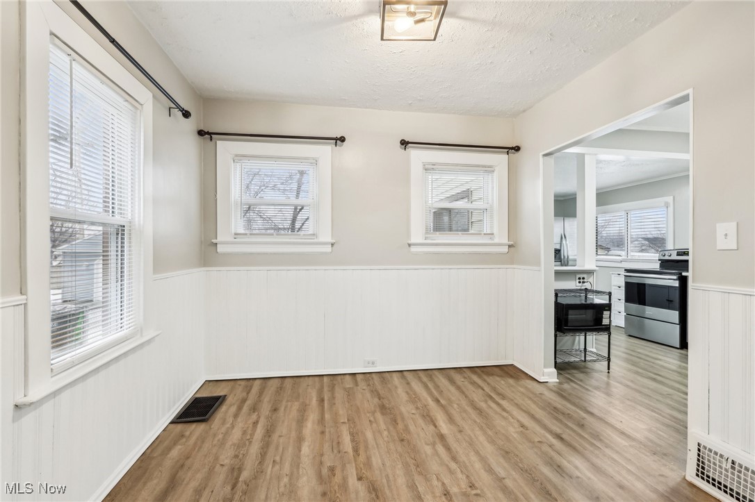 1573 Roselawn Road Cleveland, OH 44124 - Photo 10 of 25 Unfurnished room featuring plenty of natural light, a textured ceiling, and light hardwood / wood-style flooring