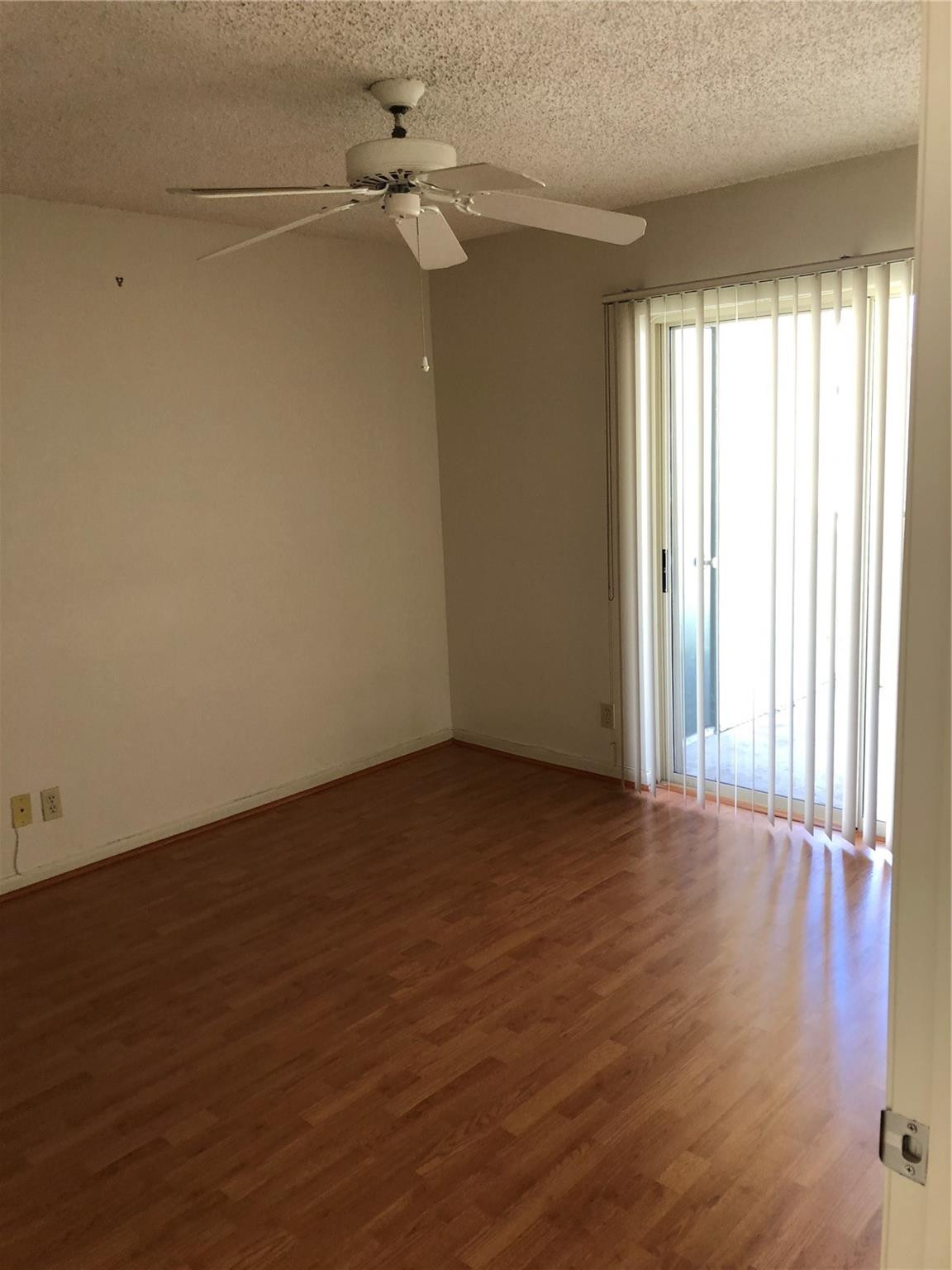 6331 La Costa Drive, Unit G Boca Raton, FL 33433 - Photo 3 of 12 a view of an empty room with a window and wooden floor